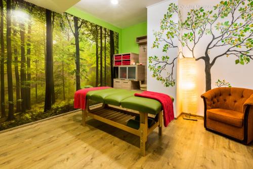 Best Western Bucovina Club de Munte في جورا هومورولوي: غرفة معيشة بها لوحة جدارية لغابة