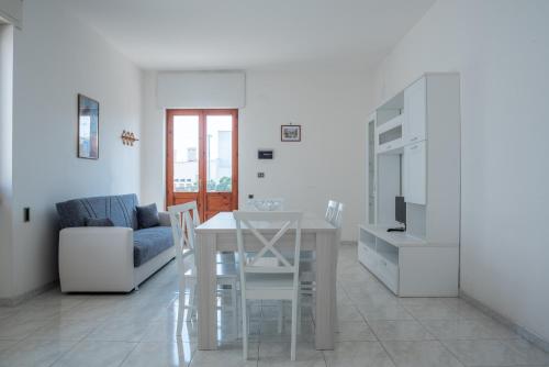un soggiorno bianco con tavolo e divano di Residence Via Milano a Marina di Mancaversa