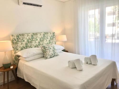 une chambre avec un lit blanc avec deux serviettes dessus dans l'établissement Casa do Sul Guest House, à Lagos