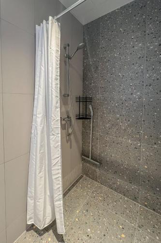 a shower with a shower curtain in a bathroom at Kastani Factory Apartments in Tartu