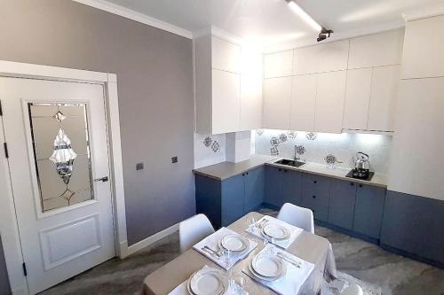 a kitchen with a table and chairs and a kitchen with blue cabinets at Апартамент keruen saray in Türkistan