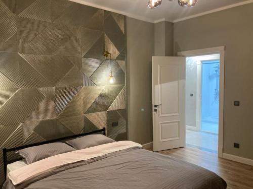 a bedroom with a bed with a geometric wall at Апартамент keruen saray in Türkistan