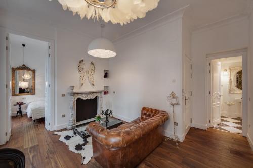 a living room with a leather couch and a fireplace at Purple Dog Suites in León