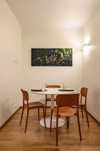a table and chairs in a room with a painting on the wall at Kastani Factory Apartments in Tartu