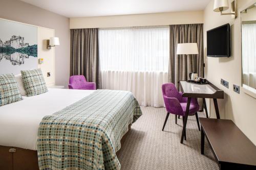 a hotel room with a bed and a desk at Mercure Swansea Hotel in Swansea