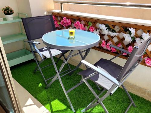 einen Tisch und Stühle auf einem Balkon mit Blumen in der Unterkunft Appartement El Campello plage in El Campello