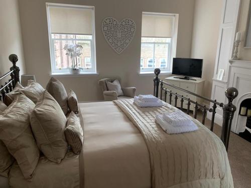 a bedroom with a large bed and a tv at Strother's Townhouse in Berwick-Upon-Tweed