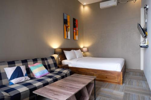 ein kleines Zimmer mit einem Bett und einer Couch in der Unterkunft The Lavana Valvilla in Timuran