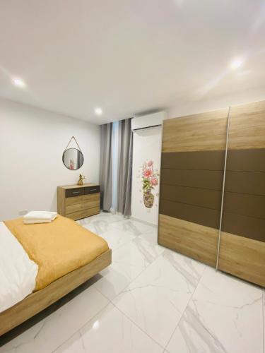 a bedroom with a bed and a large wooden cabinet at Spacious Deluxe Seaside Escape in St Paul's Bay