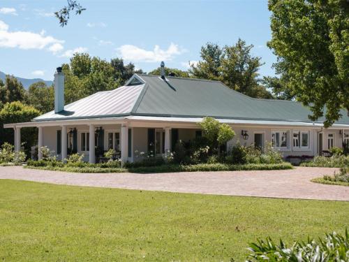a white house with a gray roof at Woodlands Villa in George