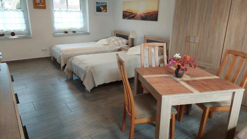 una camera con due letti e un tavolo e una sala da pranzo di Ferienwohnung "Jasmund" in Sagard auf Rügen a Sagard