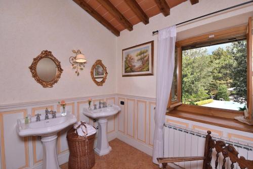 baño con 2 lavabos y ventana en Villa with pool in chianti Rufina area (19 sleeps) with cooking class included en San Godenzo