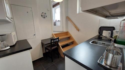 a kitchen with a sink and a counter top with a table at Ferienwohnung "Jasmund" in Sagard auf Rügen in Sagard