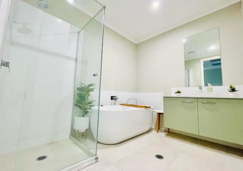 ein Badezimmer mit einer Dusche, einer Badewanne und einem Waschbecken in der Unterkunft Coolalta Cottage - Hunter Valley in Nulkaba