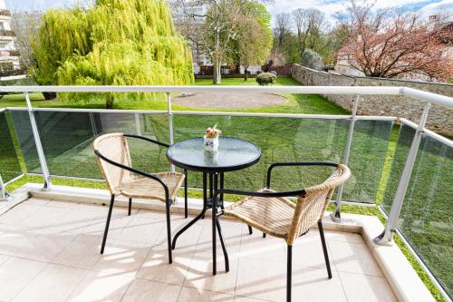 une table et deux chaises sur un balcon dans l'établissement The Green Home - Quiet and Fully Equipped High-End Studio with parking, Évry-Courcouronnes
