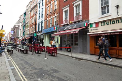 a street with tables and chairs on a city street at Stay in the heart of Soho in London