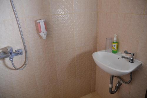 a bathroom with a shower and a sink at Roemah Canting Homestay in Yogyakarta