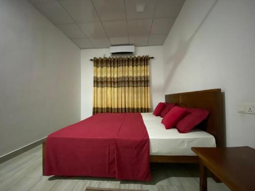 um quarto com uma cama grande e almofadas vermelhas em Rock View Home Stay em Dambulla