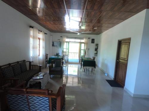 ein Wohnzimmer mit Stühlen, einem Tisch und einer Decke in der Unterkunft Rock View Home Stay in Dambulla