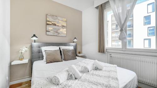um quarto branco com uma cama grande e uma janela em HOMEY GOLD - Hyper centre/Proche Tram/Wifi gratuit em Annemasse