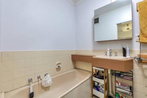 a bathroom with a tub and a sink at Joyful Esplanade City Stay in Darwin