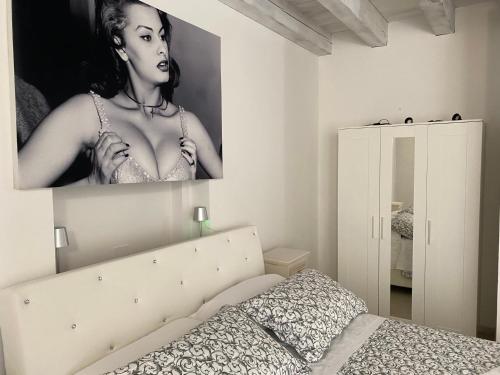 ein Schlafzimmer mit einem Bild einer Frau an der Wand in der Unterkunft Cinema Rooms Fiera Verona in Verona