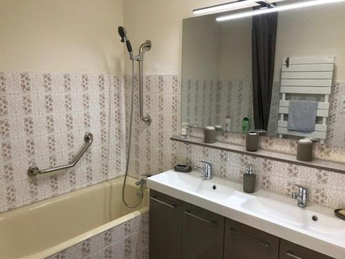 La salle de bains est pourvue d'une baignoire, de 2 lavabos et d'une douche. dans l'établissement Studio Calme à 5min de l'Océan - Parking et Balcon Aménagé - FR-1-4-521, à Saint-Jean-de-Luz