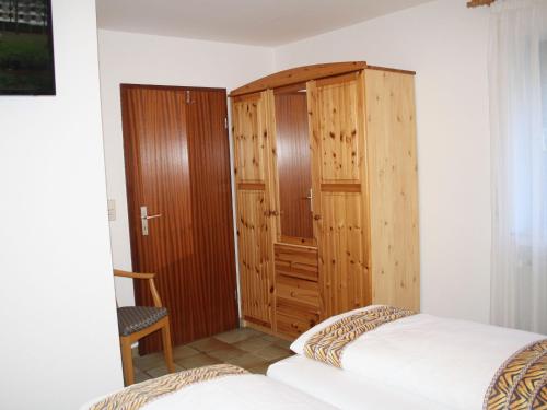 a bedroom with a bed and a wooden cabinet at FEWO Bilstein in Lennestadt
