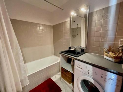 une salle de bain avec un lave-linge et une baignoire dans l'établissement Appartement T2 décoré proche plage à Quiberon - FR-1-478-64, à Quiberon