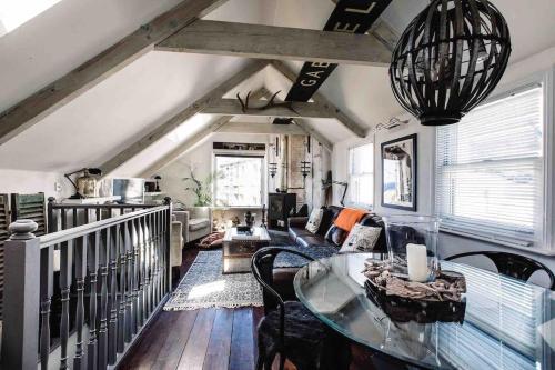 a living room with a table and chairs in a room at The Old Stores, Luxury beach side selfcatered holiday cottage above the beach in Porthleven