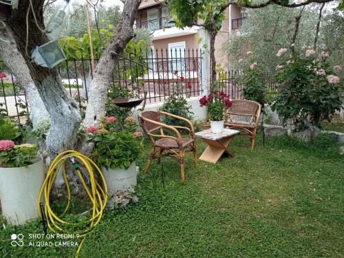 a garden with chairs and a table and a tree at BELLA-CAZA in Mákri