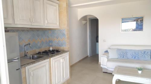 a kitchen with a sink and a couch in a room at Sardegna Top Golfo Di Marinella in Golfo Aranci