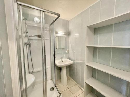 une salle de bain blanche avec une douche et un lavabo dans l'établissement Studio charmant 30m² à Quiberon, proche plage, quartier calme, 4 pers, bien équipé - FR-1-478-104, à Quiberon
