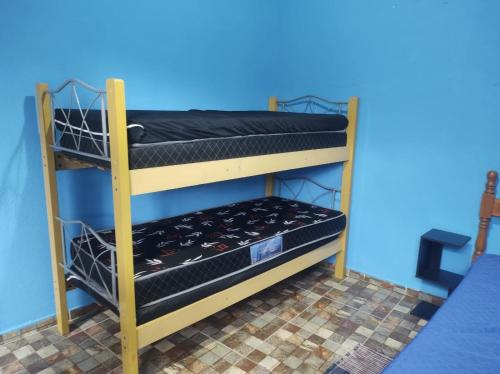 two bunk beds in a room with a blue wall at Mar&cia chácara temporada in São Sebastião