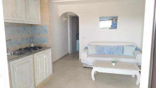 kuchnia i salon z kanapą w obiekcie Sardegna Top Golfo Di Marinella w mieście Golfo Aranci
