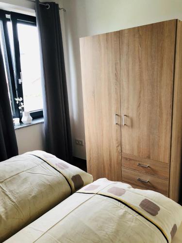 a bedroom with two beds and a wooden cabinet at Ferienwohnung Vivien in Rieden
