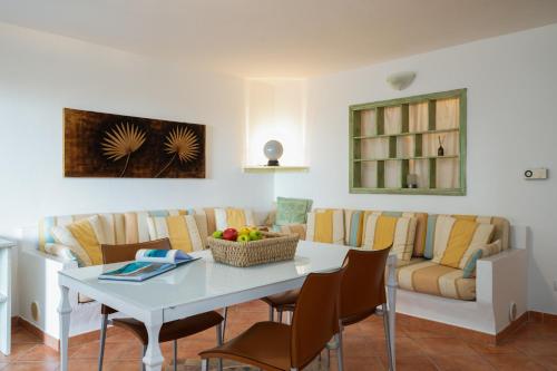 sala de estar con mesa, sillas y sofá en Sea Shell - Klodge en Olbia