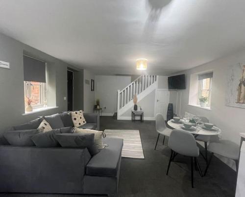 a living room with a couch and a table at Cedar House - 2 bedroom house with free parking by ShortStays4U in King's Lynn