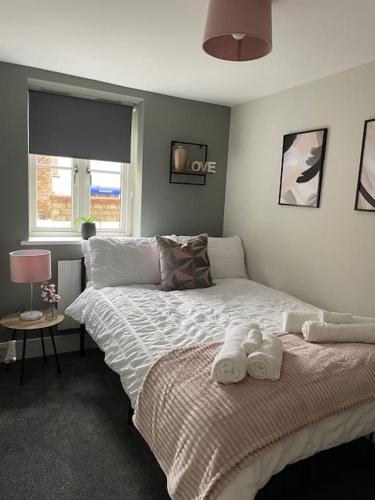 a bedroom with a bed with towels on it at Cedar House by ShortStays4U A modern 2 bedroom house with free parking in town centre! in King's Lynn