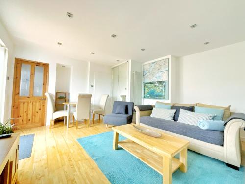 een woonkamer met een bank en een tafel bij White Eden, King bed, Free parking, Private patio, Fast WiFi, Dog, Family, Biker Friendly, Central Cornwall in St Austell