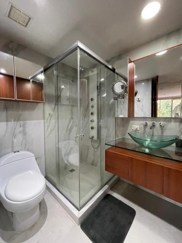 uma casa de banho com um chuveiro, um WC e um lavatório. em Lujoso Apartamento parque el Virrey em Bogotá