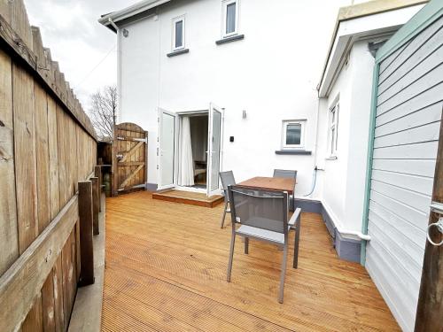 un balcone con tavolo e sedie su un edificio di White Eden, King bed, Free parking, Private patio, Fast WiFi, Dog, Family, Biker Friendly, Central Cornwall a St Austell