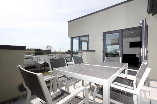 uma mesa branca e cadeiras numa varanda em Burrow Park Holiday Apartments em Rosslare