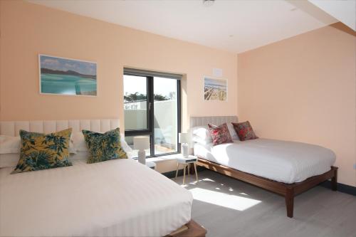 a bedroom with two beds and a window at Burrow Park Holiday Apartments in Rosslare