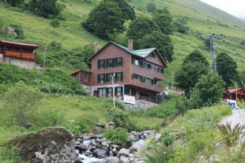 uma casa no lado de uma colina ao lado de um rio em Dagevi Butik Apart em Uzungol