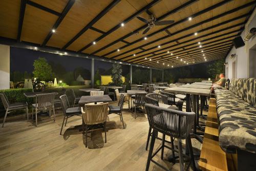 a restaurant with tables and chairs on a patio at Maxmilian Lifestyle Resort in Loučeň