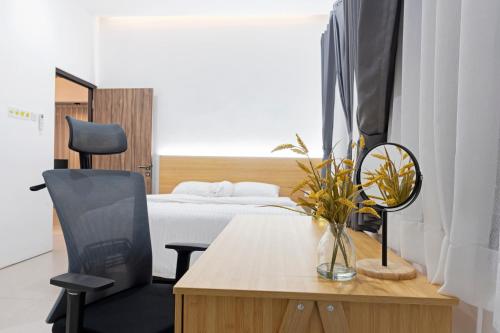 a bedroom with a bed and a desk with a chair at Urbanisia in Betek