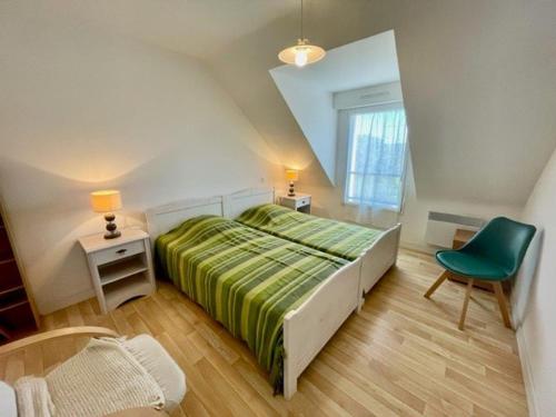 une chambre avec un lit vert et une chaise verte dans l'établissement Maison moderne à Quiberon - 8 pers, plage près, quartier calme, jardin sud, animaux acceptés - FR-1-478-172, à Quiberon