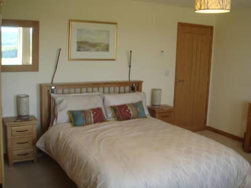 a bedroom with a large bed with two pillows at Farriers Fold in Grange Over Sands