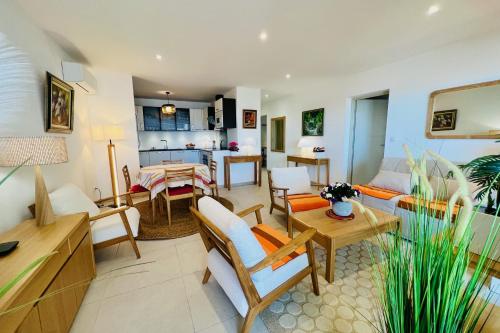 ein Wohnzimmer mit Sofa und Tisch in der Unterkunft Villa Marie 1 - Superbe appartement climatisé 2 chambres Vue Mer in Le Grau-du-Roi